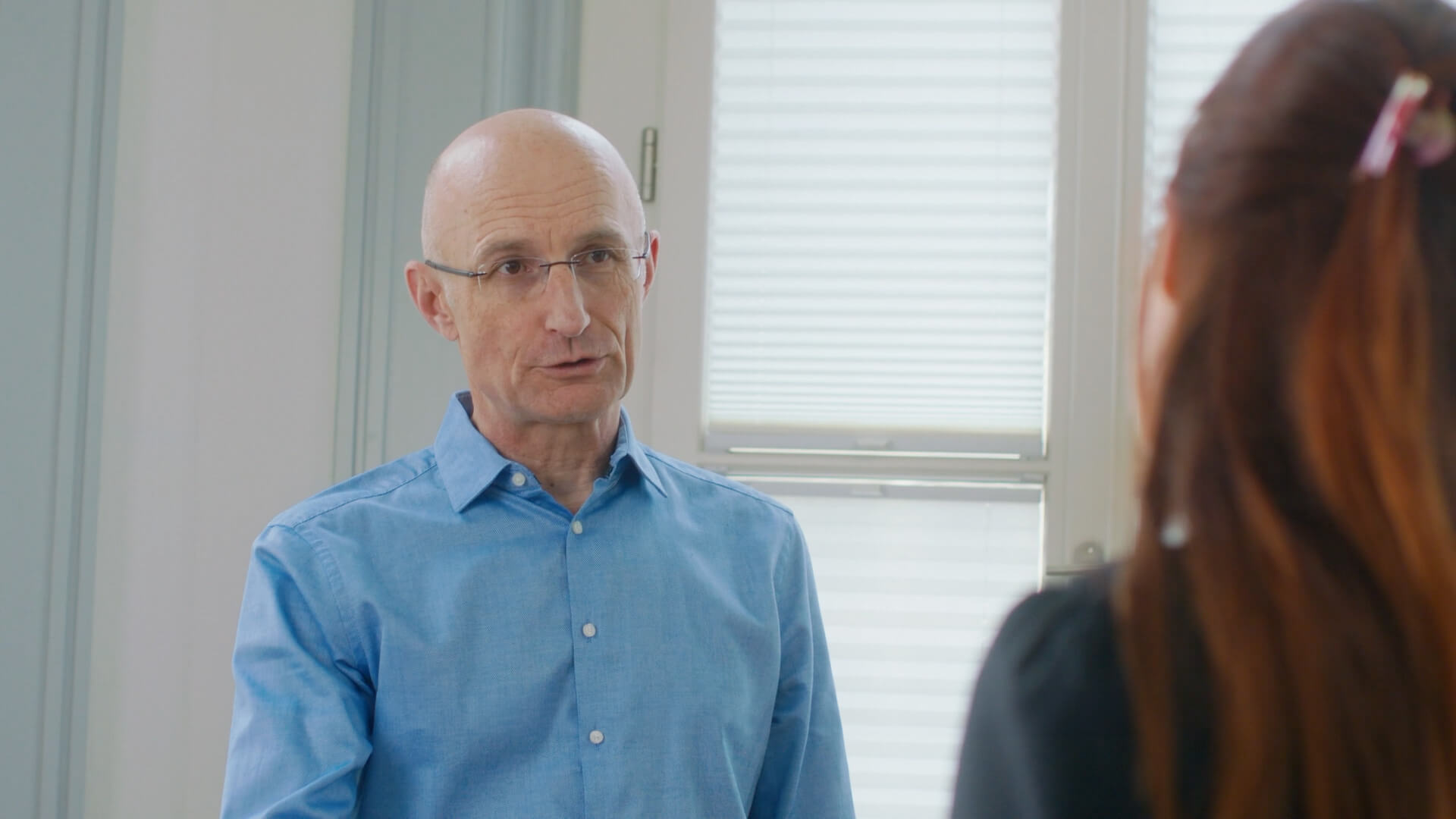 Claude Keller spricht mit einer Frau in einem Büro.