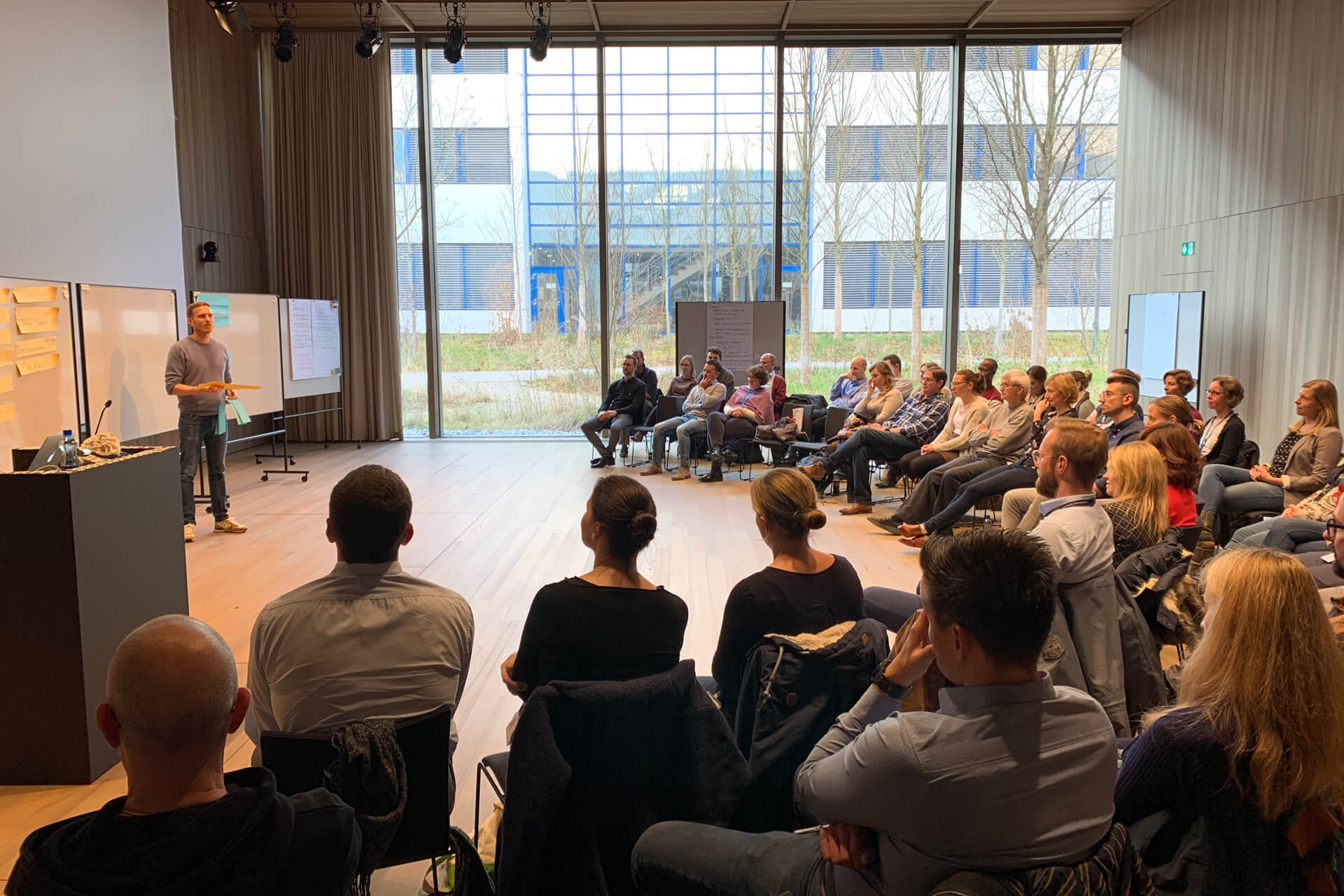 Eine Gruppe von Menschen sitzt in einem Seminarraum und schaut sich eine Präsentation an.